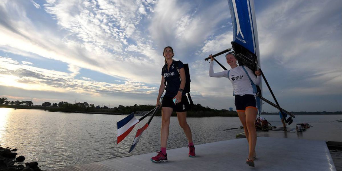 Two athletes walk on the best floating docks for rowing facilities after practice.