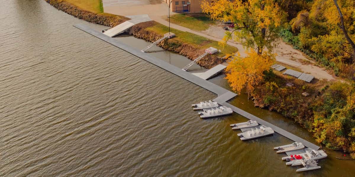 Aerial view of marina shoreline with modular floating docks and paddle boats showing dock layout ideas for public waterfront use