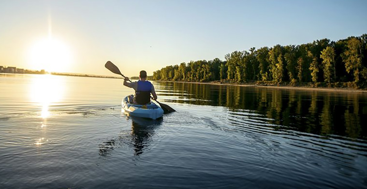 An angler paddles away to start his day fishing from a kayak.
