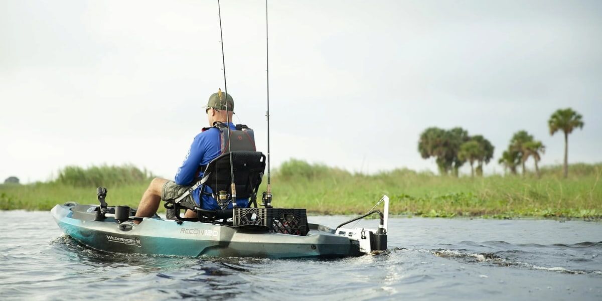 Angler fishing from a sit-on-top kayak in calm water, showcasing practical kayak fishing tips and gear setup for a successful day.