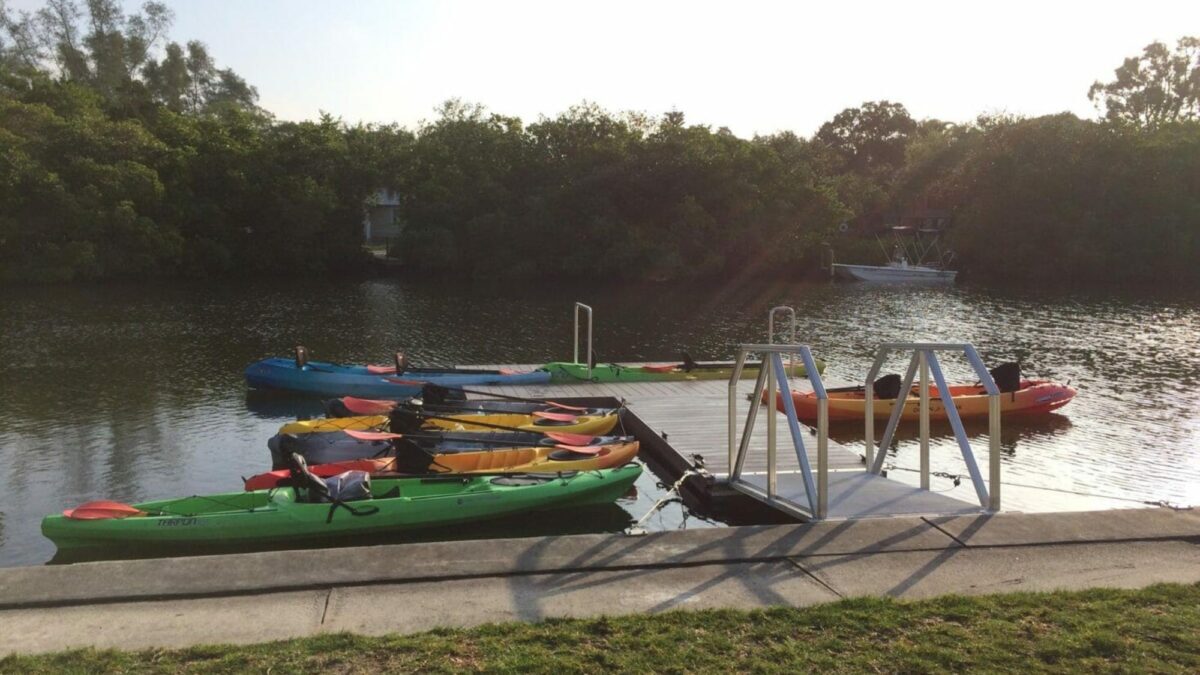Floating Docks for Summer Camps with kayaks strapped to the docks.