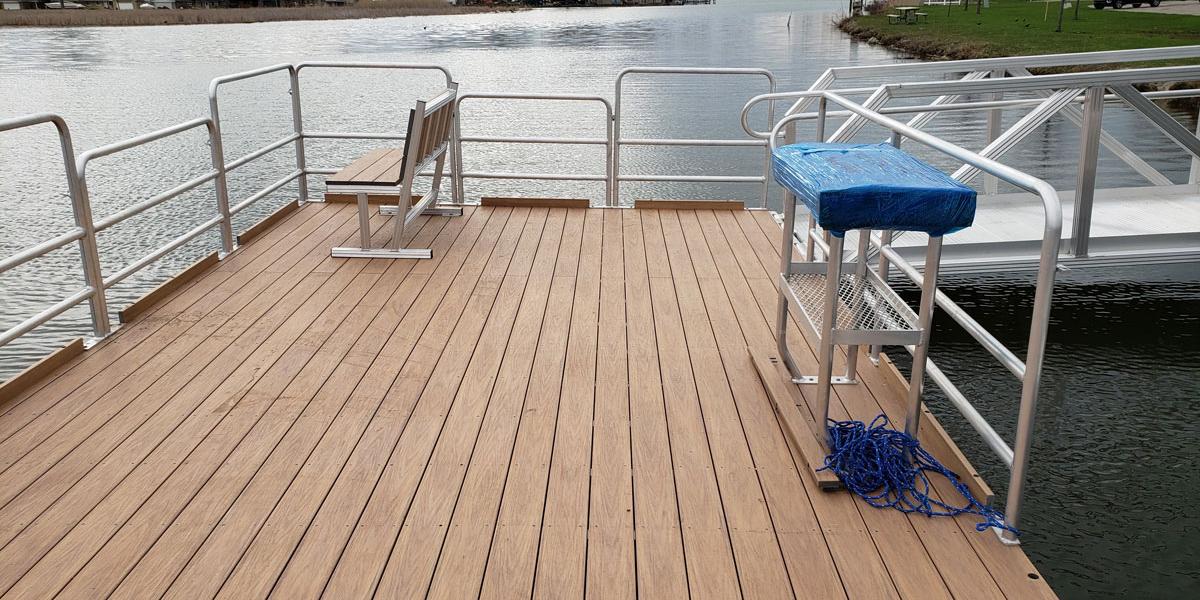 A fishing dock by AccuDock located on a Florida canal with aluminum guardrails and fishing accessories.