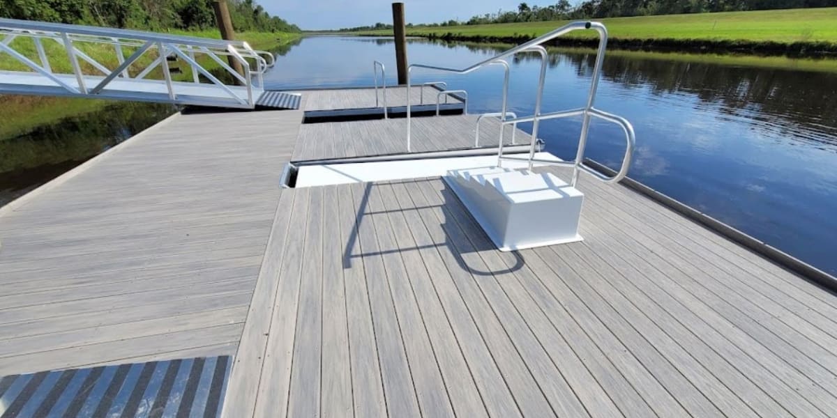 ADA kayak launch with step-down transfer platform, assist rails, and low-profile dock providing accessible water entry for all users.