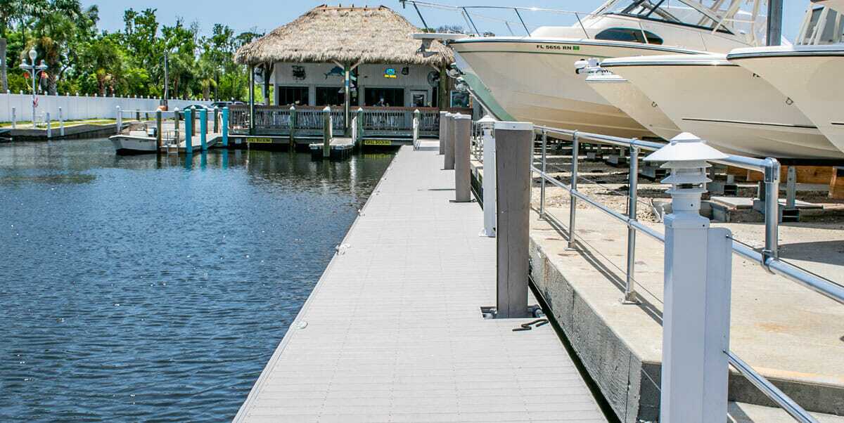 a converging point of view of a well-managed marina floating dock with a tiki bar at the end