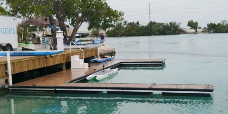 Floating dock and paddleboards at a calm shoreline used by resorts with water access for easy guest entry to the water.