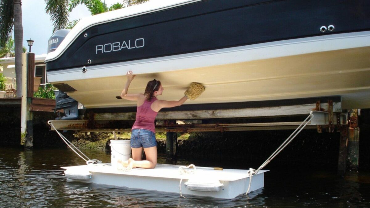 Woman standing on Floating Work Dock cleaning her boat.