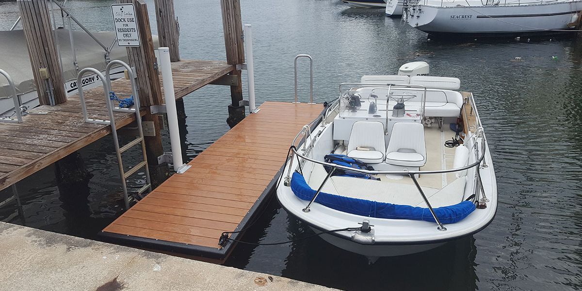 A boat docked at a marina that is protected by dock bumper guards from damage.